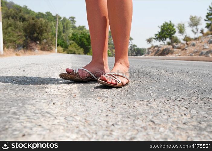 female feet are standing on country road