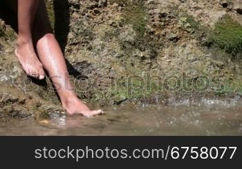 female feet in a mountain stream