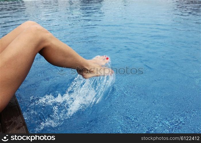 Female feet making splashes. Female feet in the pool making splashes
