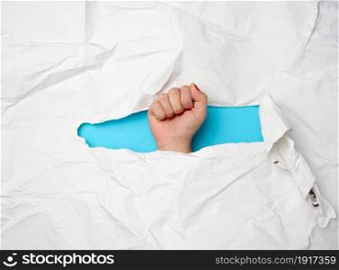 female fist sticking out of torn hole on white paper, freedom
