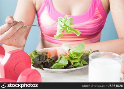 Female fitness eating fresh salad and milk, Healthy lifestyle concept