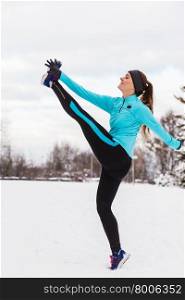 Female fitness sport model outdoor in cold winter weather . Sports and activities in winter time. Slim fit fitness woman outdoor. Athlete girl training wearing warm sporty clothes outside in cold snow weather.
