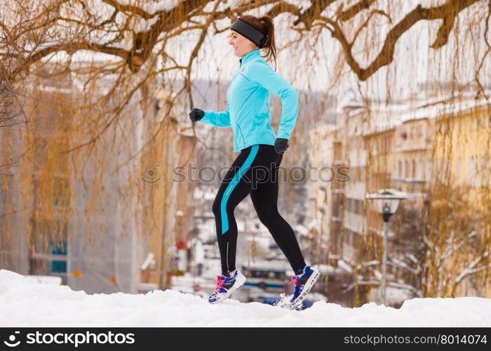 Female fitness sport model outdoor in cold winter weather . Sports and activities in winter time. Slim fit fitness woman outdoor. Athlete girl training wearing warm sporty clothes outside in cold snow weather.