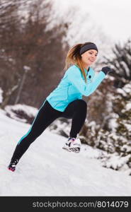 Female fitness sport model outdoor in cold winter weather . Sports and activities in winter time. Slim fit fitness woman outdoor. Athlete girl training wearing warm sporty clothes outside in cold snow weather.