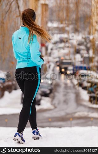 Female fitness sport model outdoor in cold winter weather . Sports and activities in winter time. Slim fit fitness woman outdoor. Athlete girl training wearing warm sporty clothes outside in cold snow weather.