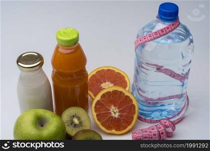 Female fitness still life. Healthy food, fruit, juice and water on grey background. Fitness, sports and healthy lifestyle concept.. Female fitness still life. Healthy food, fruit, juice and water on grey background.