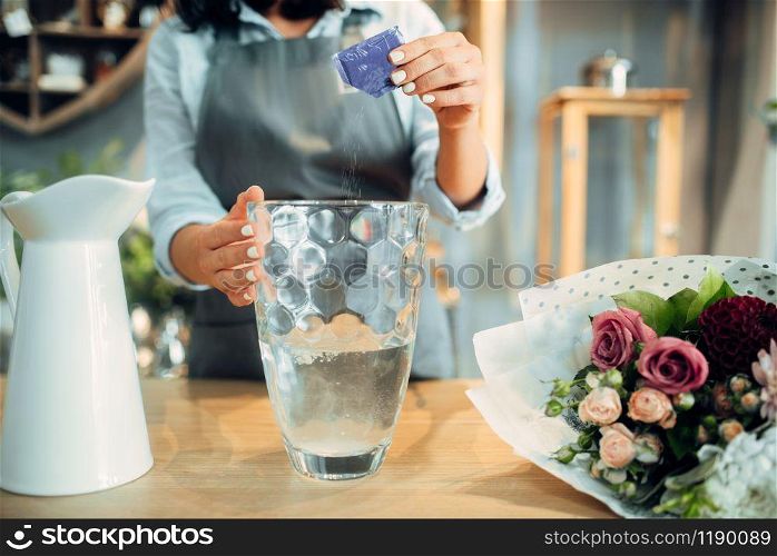 Female florist adds fertilizer to the water for flowers. Floristry service, floristic business, floral shop
