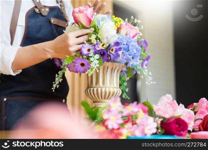 Female Florist at work using Arranging making beautiful Artificial bouquet vest at flower shop, business, sale and floristry craft and hand made concept