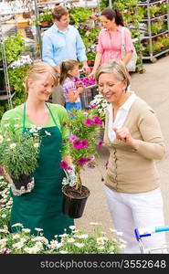 Female florist give advice to senior customer shopping for flowers