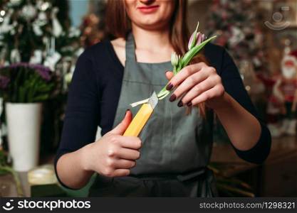 Female florist working with flowers decorate bouquet in workshop.