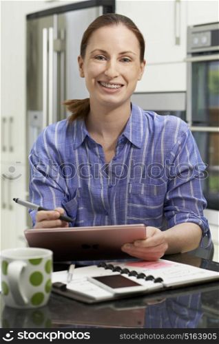 Female Freelance Worker Using Digital Graphics Tablet At Home