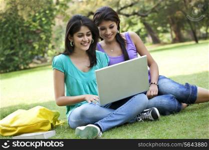 Female friends chatting on laptop