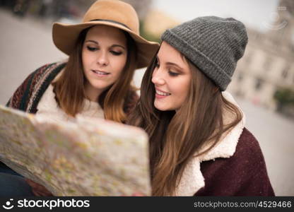 Female friends consulting a city map in the winter