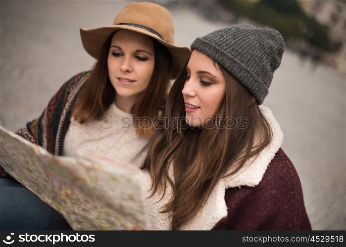 Female friends consulting a city map in the winter
