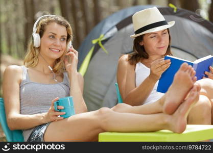 female friends doing their recreational activity outside tent