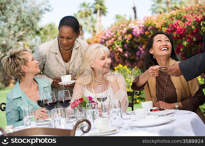 Female friends drinking at outdoor table