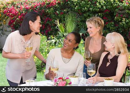 Female friends drinking wine at outdoor table