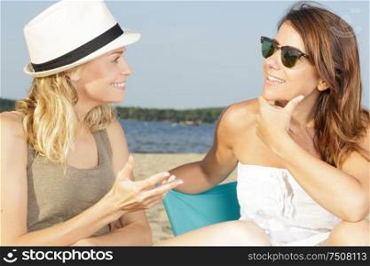female friends having a conversation on the beach
