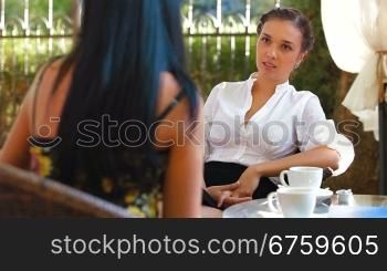 Female friends immersed in conversation at urban cafe