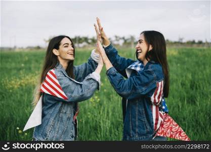 female friends laughing grass with american attributes