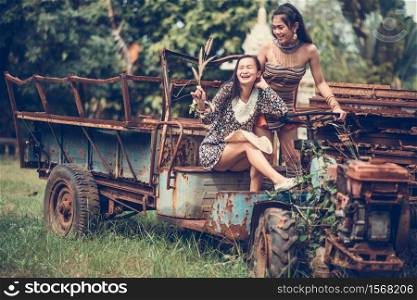 Female Friends On Abandoned Vehicle At Field