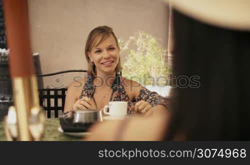 Female friends on holiday, people traveling, young women having fun on vacation, two happy girls smiling in Havana, Cuba, sitting at bar, smoking e-cig in cafeteria, talking, drinking coffee