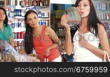 Female Friends Testing and Buying Cosmetics in Beauty Department