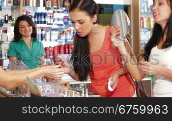 Female Friends Testing Lipstick in Beauty Department