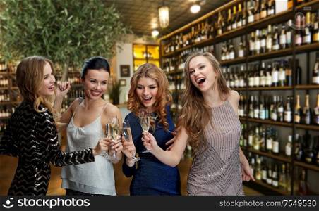 female friendship, leisure and luxury concept - happy women drinking champagne over restaurant or wine bar background. women drinking champagne at bar or restaurant