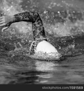 Female front crawl swimmer with tattoos during training