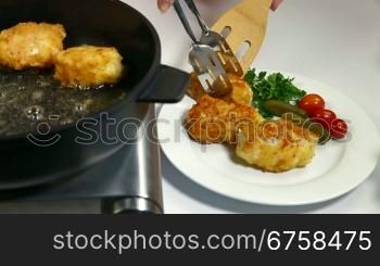 Female frying chicken breast roll on a pan.