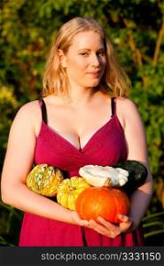 Female gardener presenting pumpkin from the harvest for thanksgiving