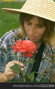 Female Gardener Smelling A Rose