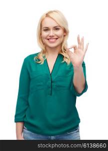 female, gender, gesture, plus size and people concept - smiling young woman in shirt and jeans showing ok hand sign