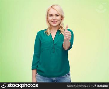 female, gender, gesture, plus size and people concept - smiling young woman in shirt and jeans showing thumbs up over green natural background