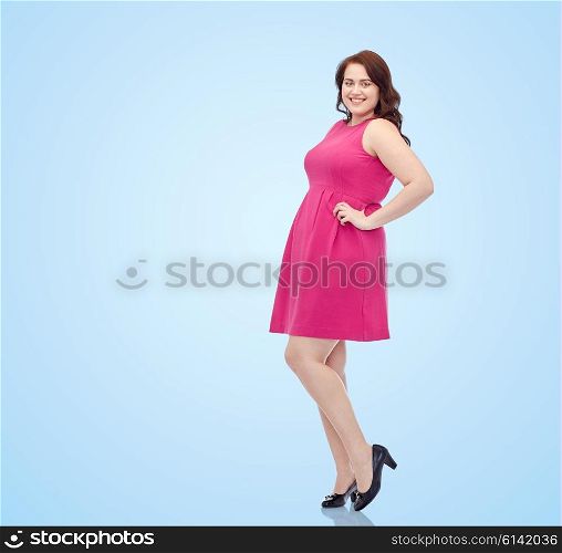 female, gender, portrait and people concept - smiling happy young plus size woman posing in pink dress over blue background