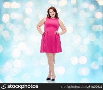 female, gender, portrait and people concept - smiling happy young plus size woman posing in pink dress background over blue holidays lights background