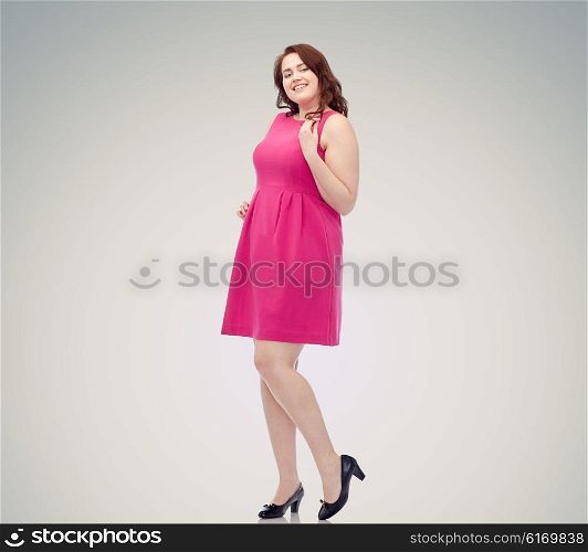 female, gender, portrait and people concept - smiling happy young plus size woman posing in pink dress over gray background