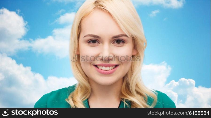 female, gender, portrait and people concept - smiling young woman face over blue sky and clouds background