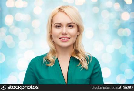 female, gender, portrait and people concept - smiling young woman face over blue holidays lights background