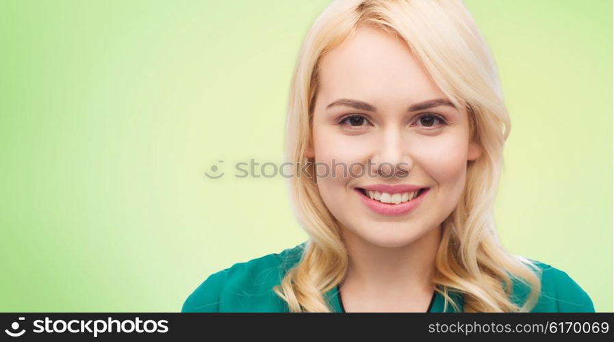 female, gender, portrait and people concept - smiling young woman face over green natural background