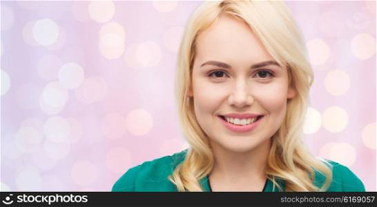 female, gender, portrait and people concept - smiling young woman face over pink holidays lights background
