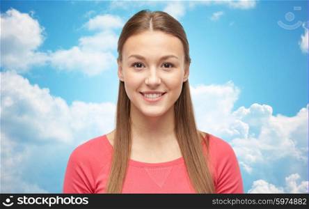 female, gender, portrait, fashion and people concept - smiling young woman or teenage girl in pink pullover over blue sky and clouds background