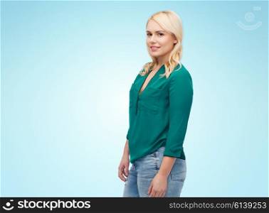 female, gender, portrait, plus size and people concept - smiling young woman in shirt and jeans over blue background