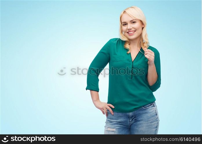 female, gender, portrait, plus size and people concept - smiling young woman in shirt and jeans over blue background