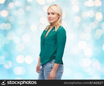female, gender, portrait, plus size and people concept - smiling young woman in shirt and jeans over blue holidays lights background