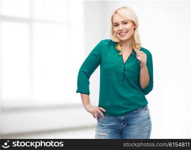 female, gender, portrait, plus size and people concept - smiling young woman in shirt and jeans over white room background