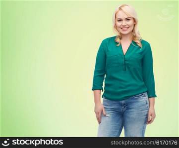 female, gender, portrait, plus size and people concept - smiling young woman in shirt and jeans over green natural background