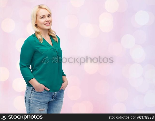 female, gender, portrait, plus size and people concept - smiling young woman in shirt and jeans over pink holidays lights background