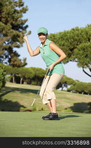 Female Golfer On Golf Course Putting On Green